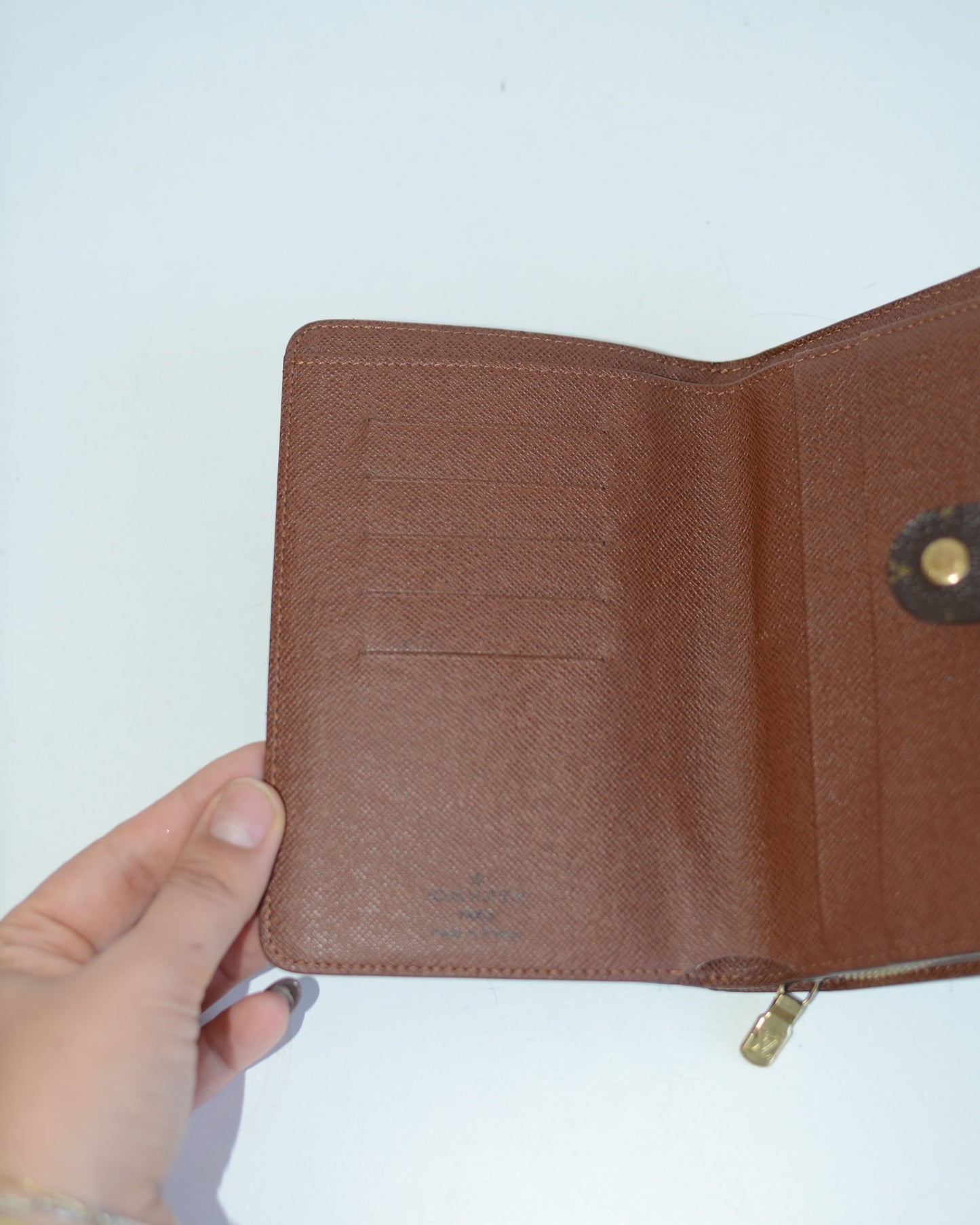 Louis Vuitton compact wallet inside lining with cardholders and inside logo on a white background